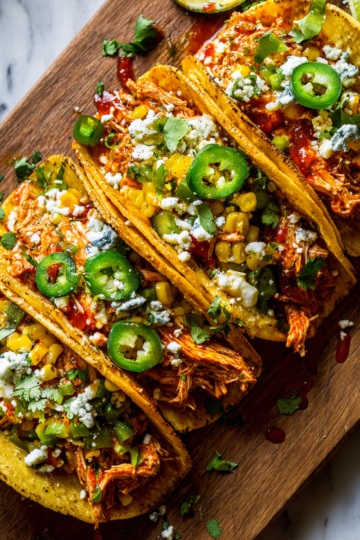 Taco di Chili di Pollo Buffalo per l'Autunno Taco di Chili di Pollo Buffalo piccante serviti con guarnizioni fresche, un piatto autunnale delizioso e confortante.